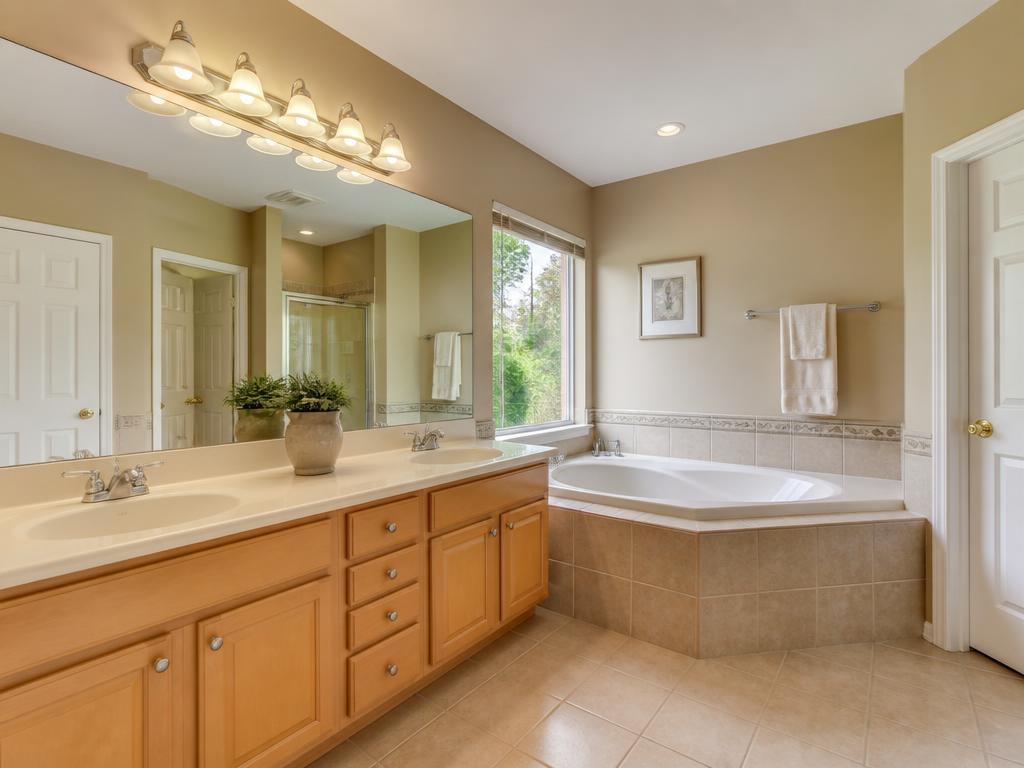 Primary bathroom with dated maple vanity and beige tile